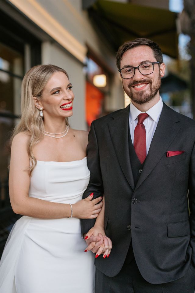 Groom in a charcoal three-piece suit with a burgundy tie